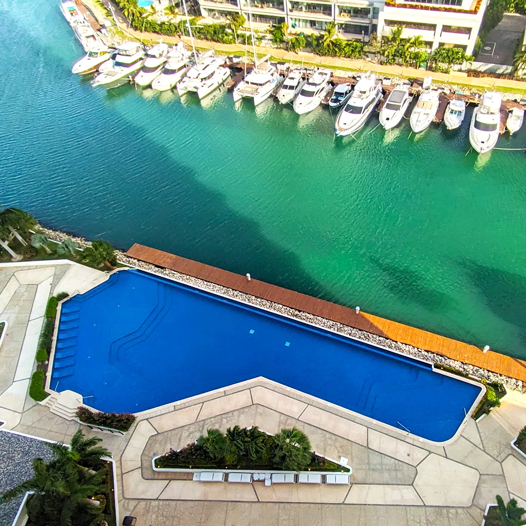 Aerial view of Puerto Cancun marina with yachts and infinity pool overlooking the canal — over 175 berths for boats up to 125 feet