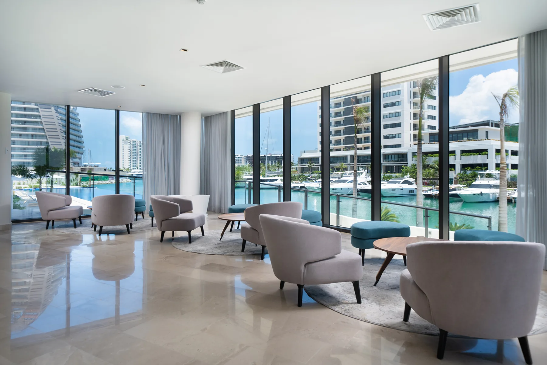 Lobby lounge con vista a marina y yates Blume Puerto Cancún