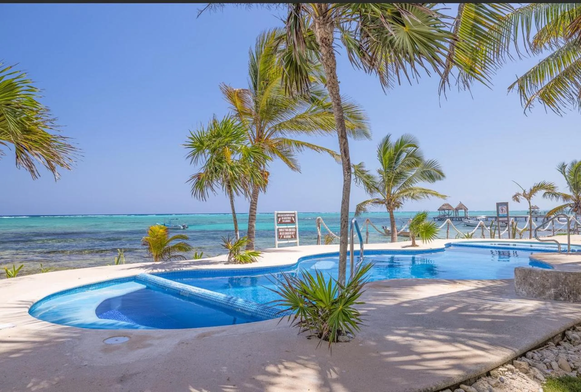 Piscina con palmeras y Mar Caribe al fondo en villa Casa Cenote, Tankah Tulum