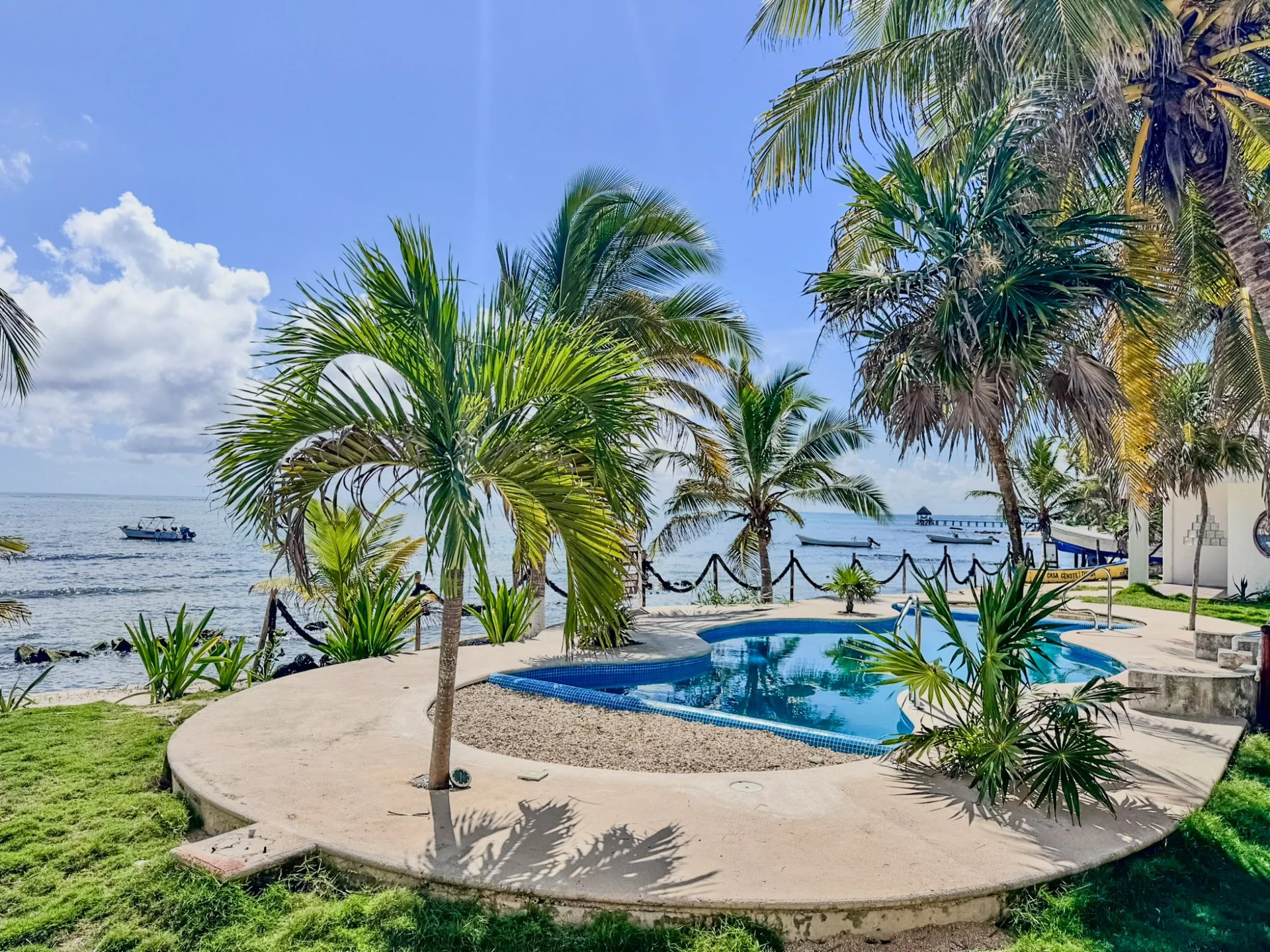 Piscina privada con palmeras y vista al Mar Caribe en villa de Casa Cenote, Tankah Tulum