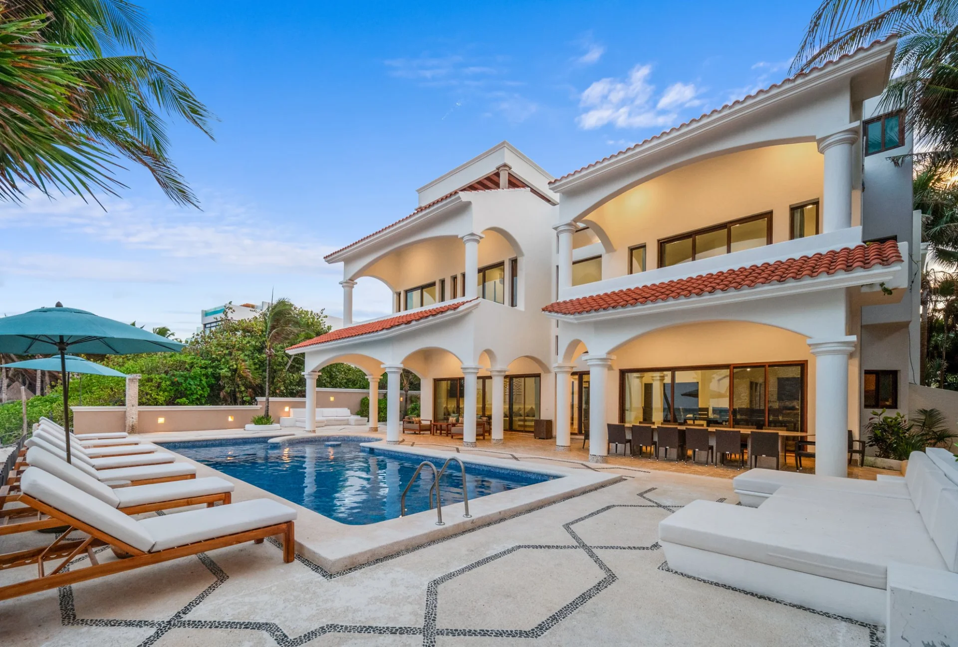 Hacienda Caracol exterior with pool and sun loungers at sunset, Bahía Soliman Tulum