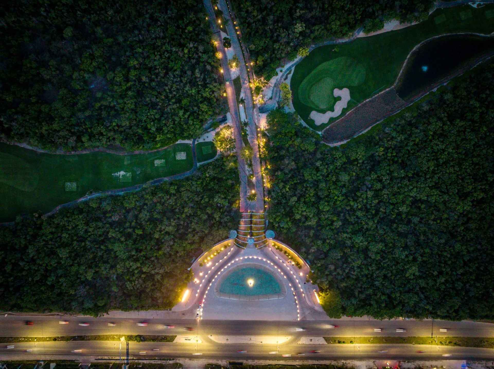 Acceso principal nocturno iluminado de La Escondida, Corasol Playa del Carmen