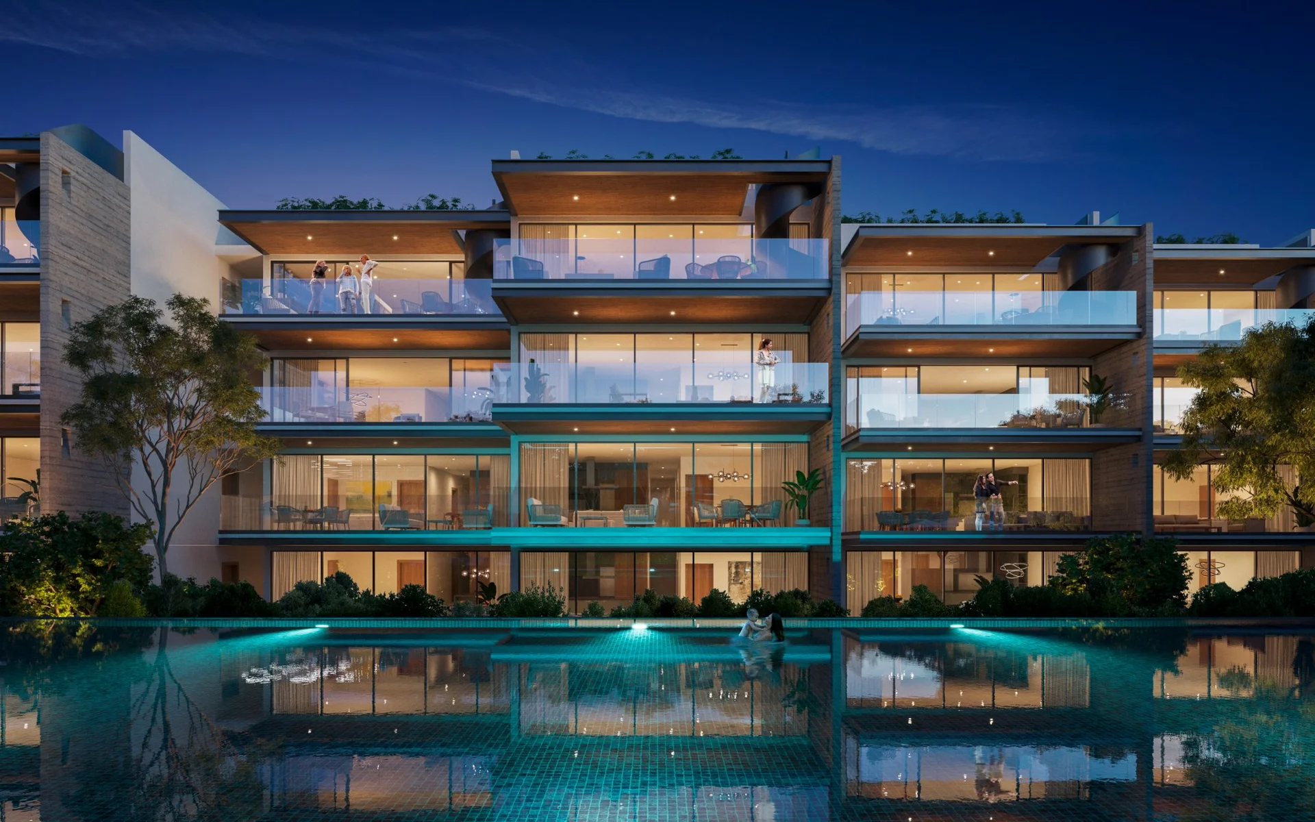 Alberca iluminada de noche en Macondo Residences Playacar, Playa del Carmen