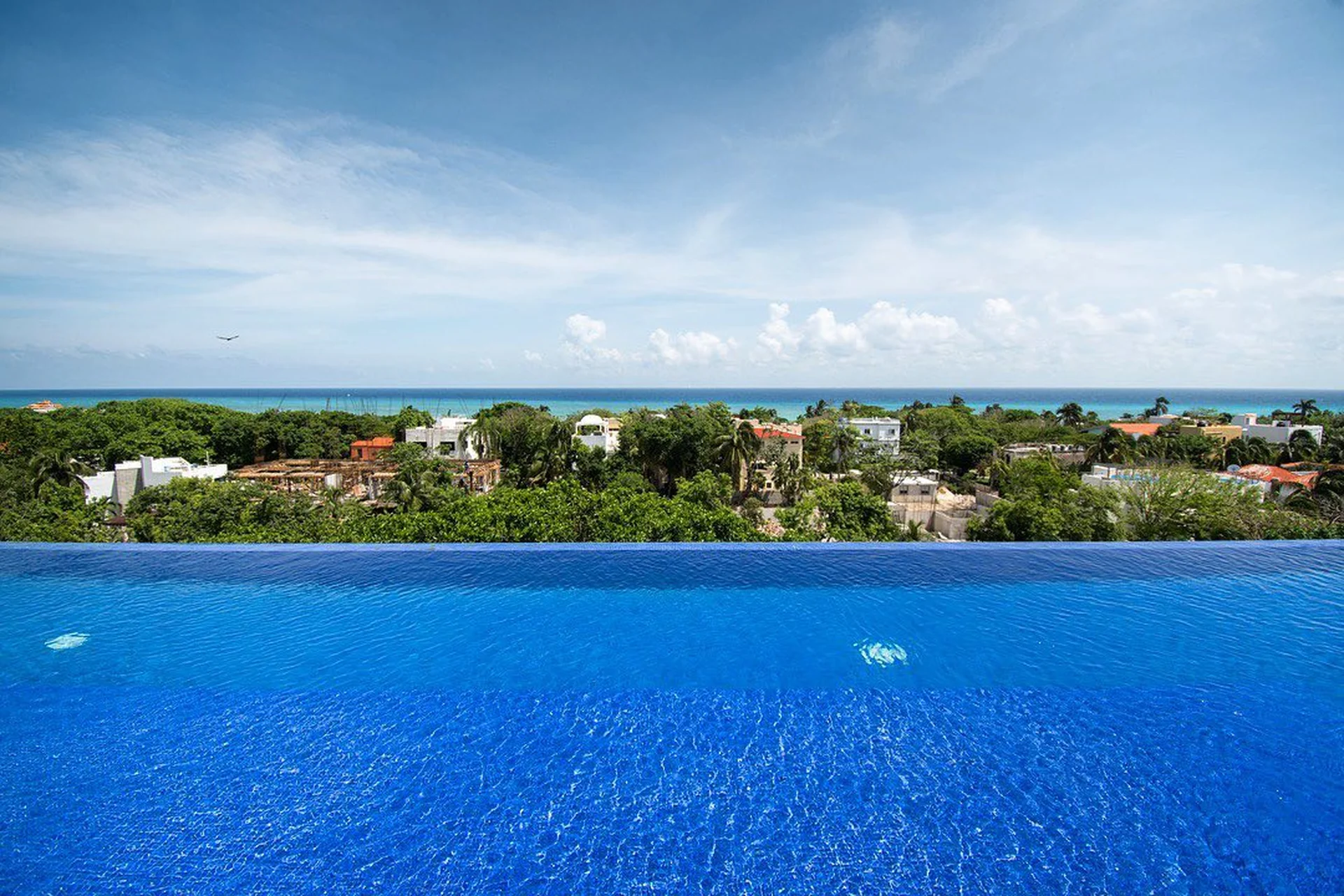 Alberca infinita con vistas al Mar Caribe en condo de lujo Mara, Playacar Playa del Carmen