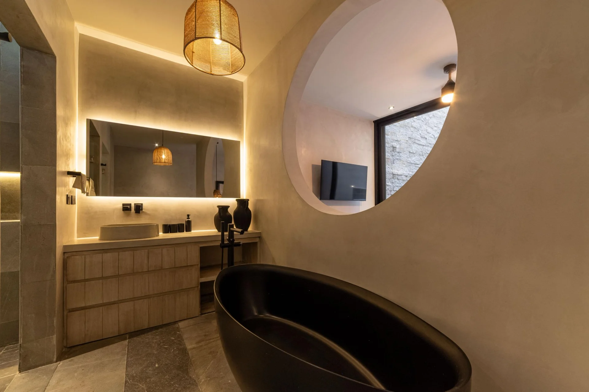 Baño con tina negra y diseño de lujo en NEEA Bahía Soliman, Tulum