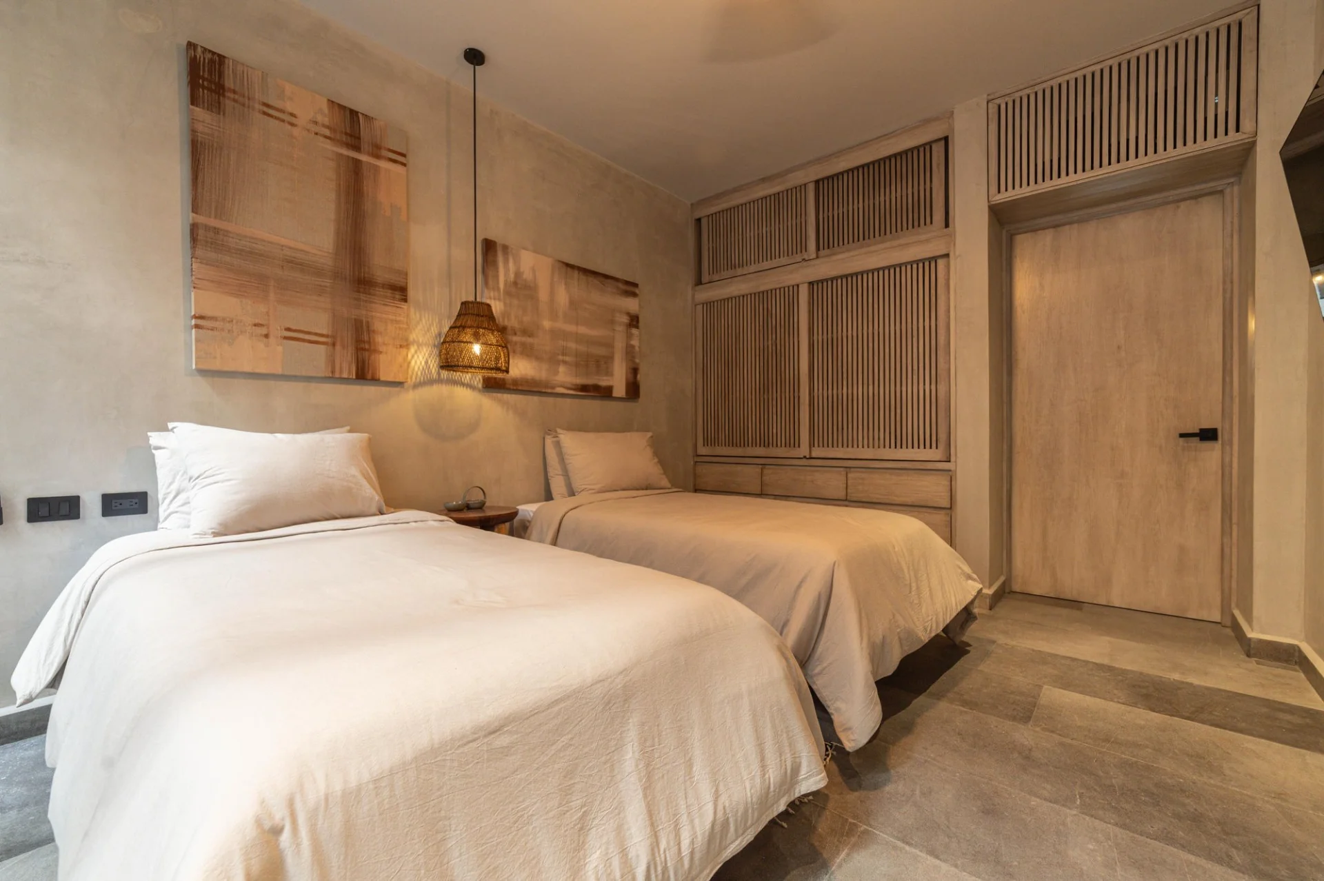 Segunda recámara con dos camas y madera en departamento NEEA Bahía Soliman, Tulum