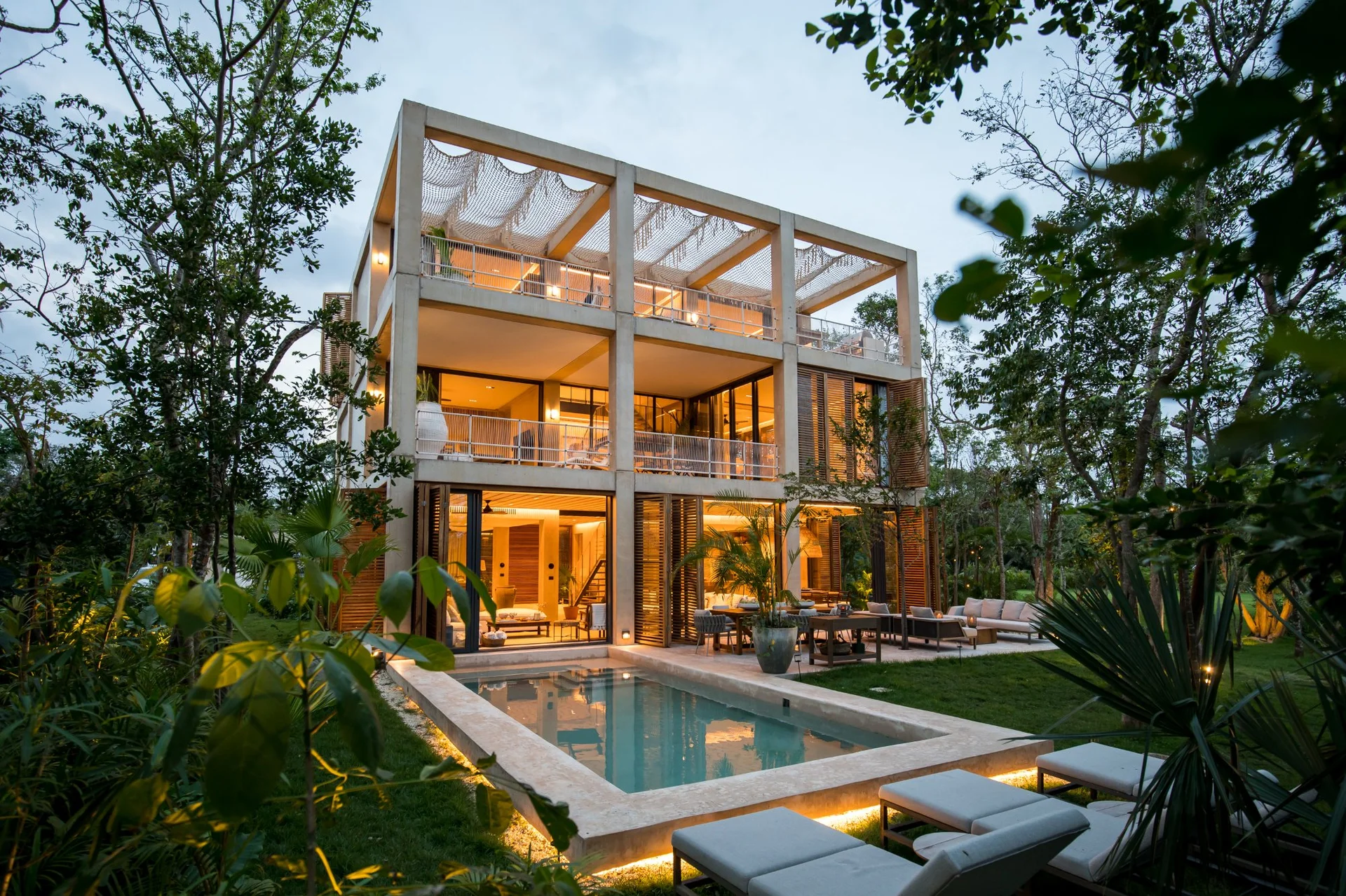 Villa de lujo con alberca iluminada de noche y selva en Palm Villas, Corasol Riviera Maya