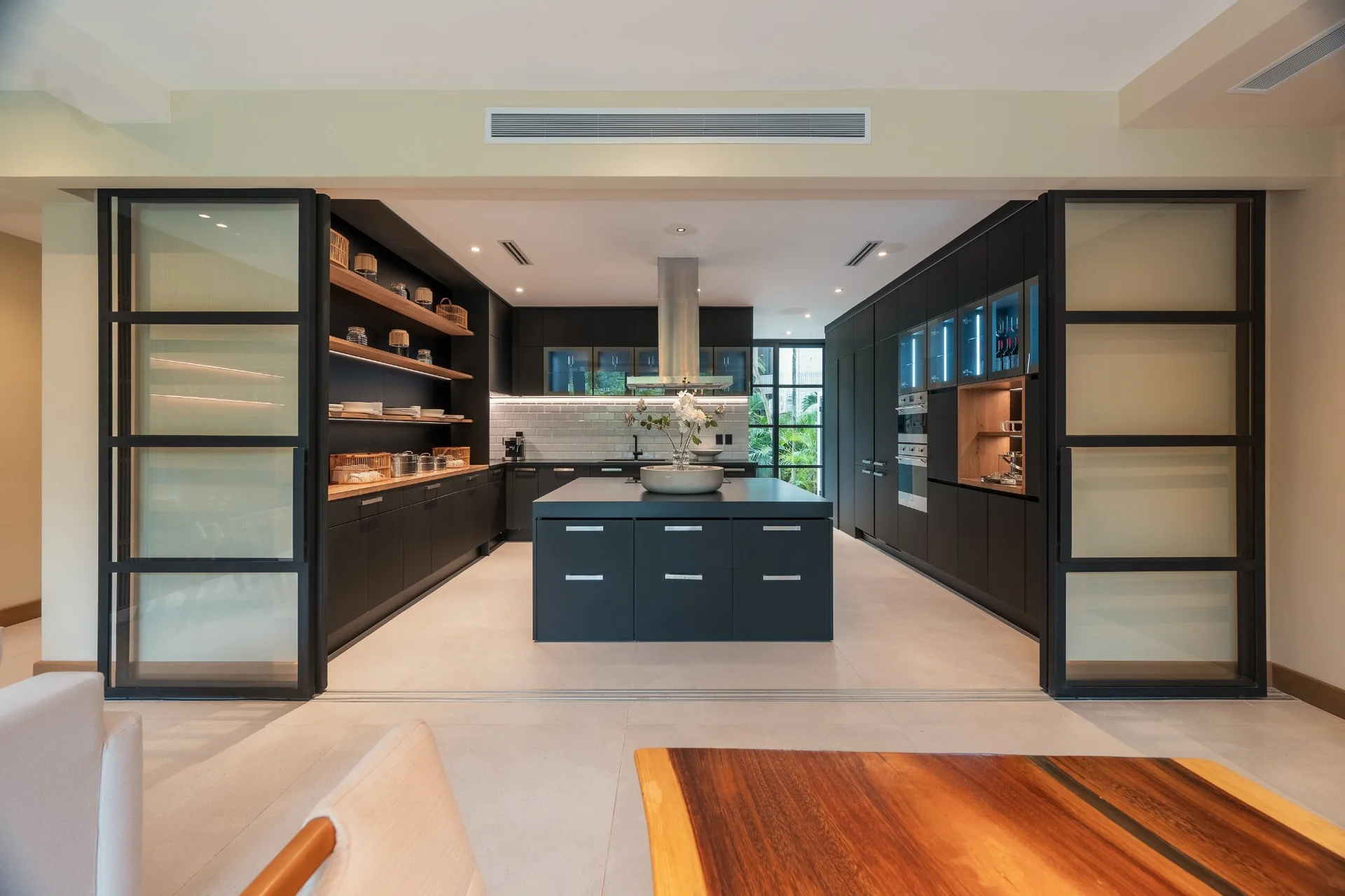 Cocina integral negra con isla central y electrodomésticos Smeg en SOLEii Playacar, Playa del Carmen