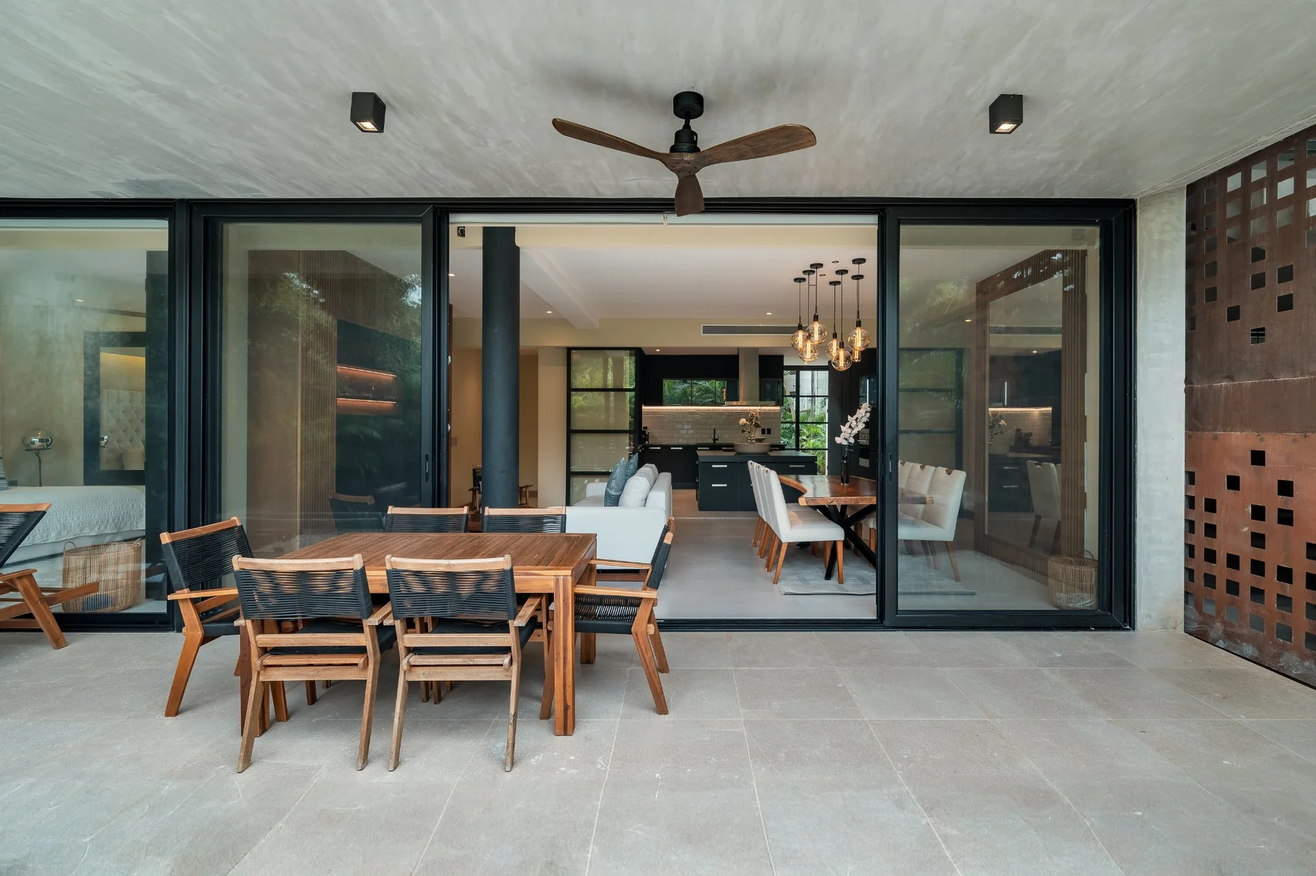 Terraza exterior con comedor y sala en departamento de lujo SOLEii Playacar, Playa del Carmen