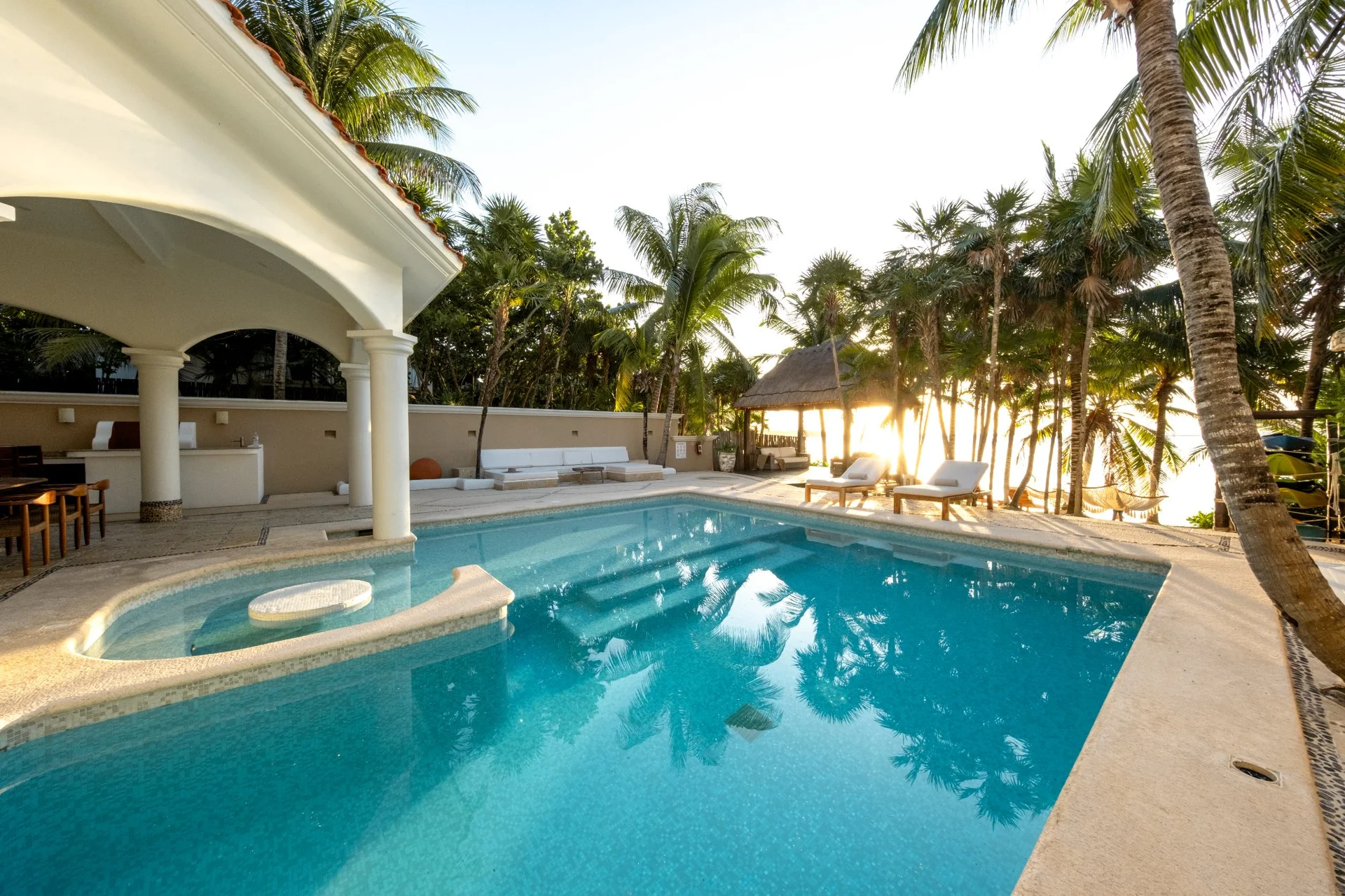 Piscina privada al atardecer con palapa en Sueño del Mar, Bahía Soliman Tulum