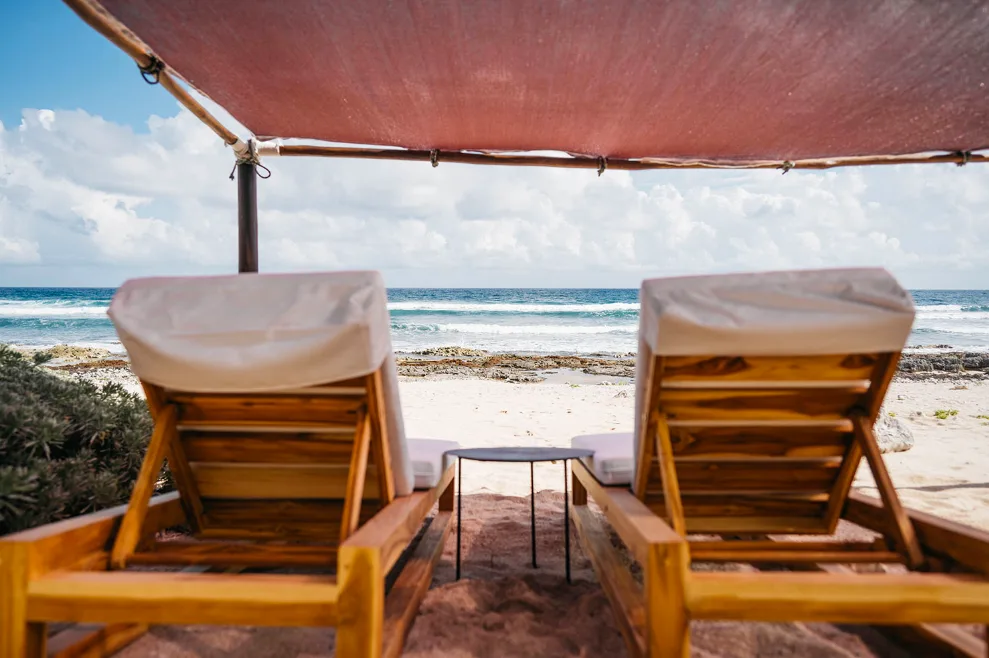 Beach club con camastros y vista al océano en Villa Amara, Tankah, Tulum