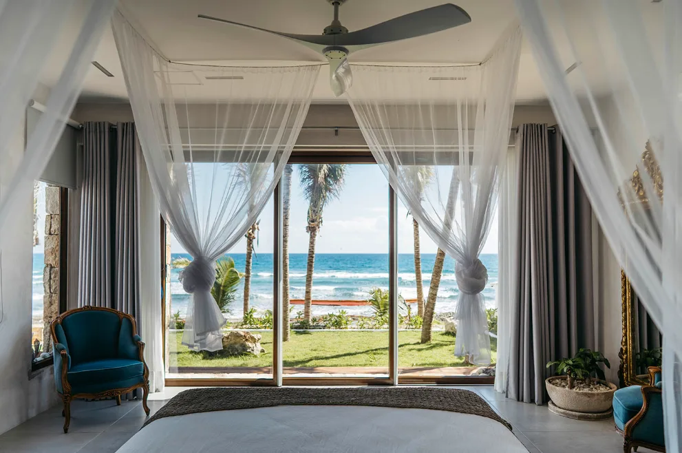Recámara principal con dosel y vista al mar en Villa Amara, Tankah, Tulum
