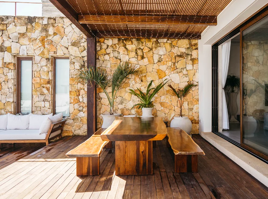 Terraza comedor exterior en piedra y madera en Villa Amara, Tankah, Tulum
