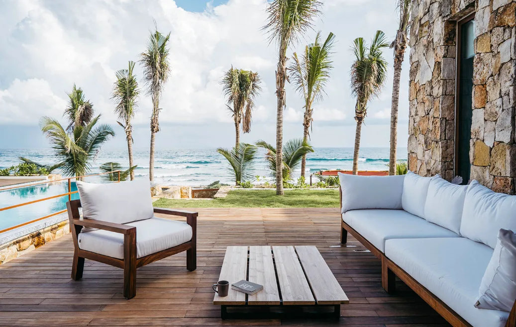 Terraza lounge con vista al mar y palmeras en Villa Amara, Bahía Tankah, Tulum