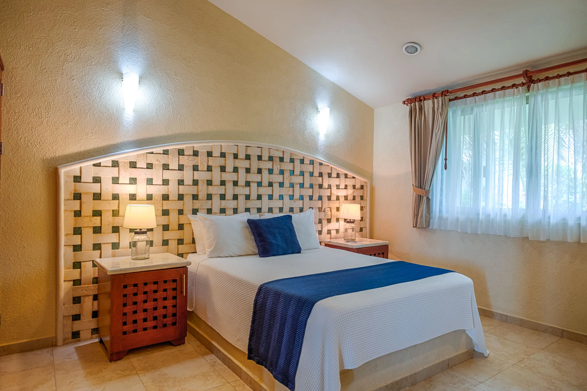 Recámara con cabecera de mosaico y mármol en Villa Arghy Tulum