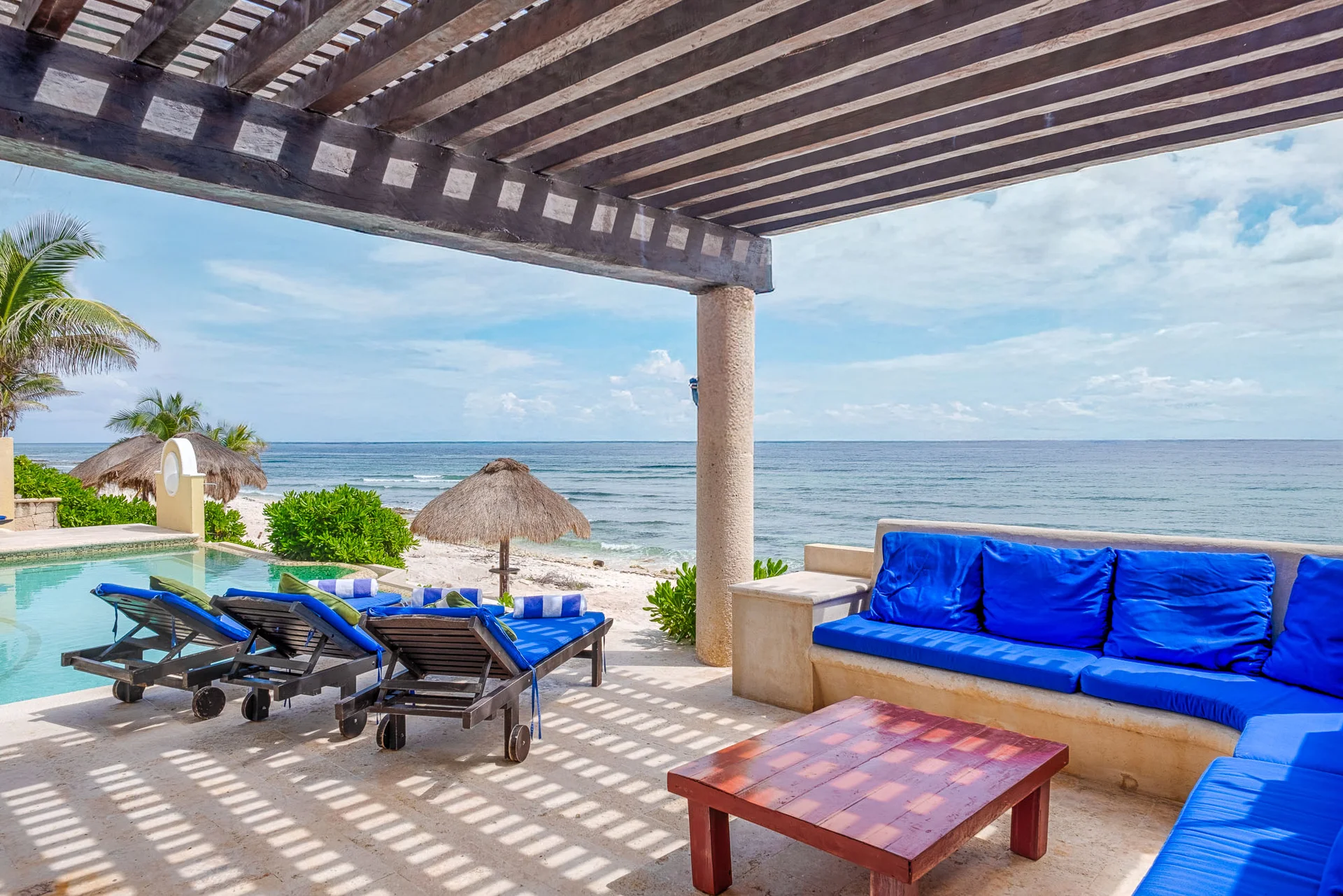 Terraza cubierta con sala exterior y piscina en Villa Arghy Bahía Tankah