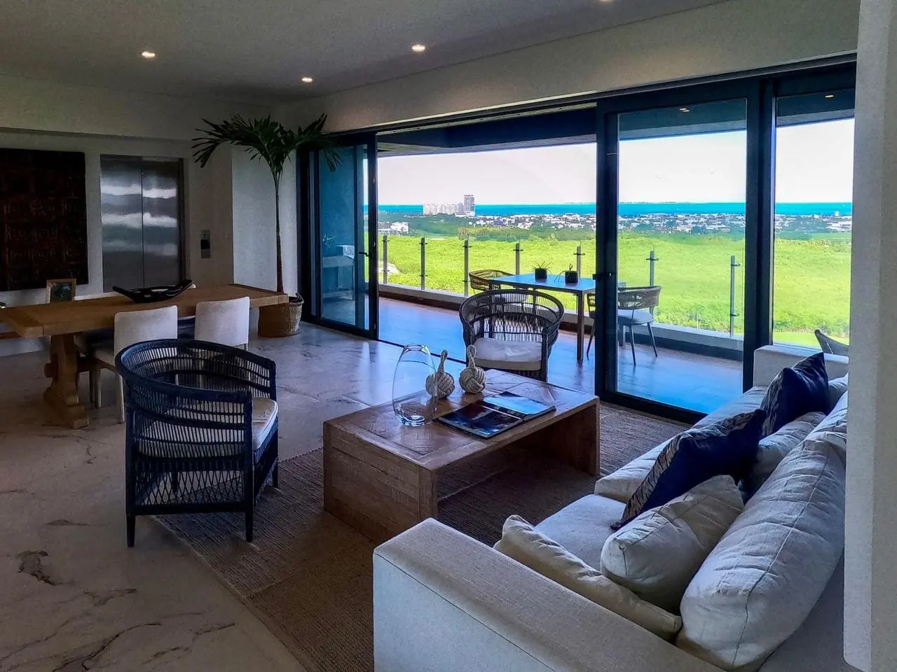 Sala de estar con piso de mármol, terraza y vista al campo de golf en Woha