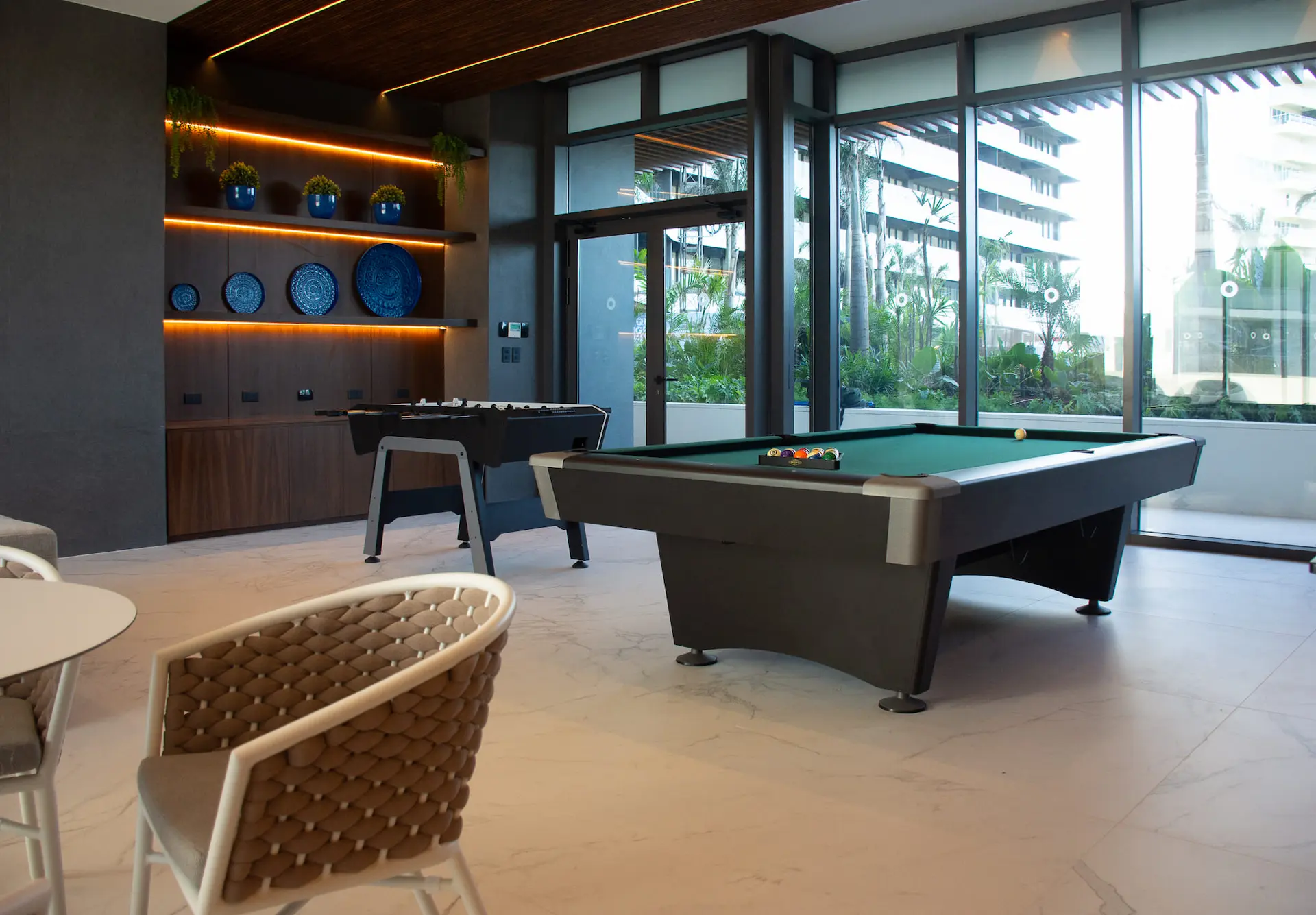 Sala de entretenimiento con mesa de billar y futbolito en las amenidades de Woha Puerto Cancún